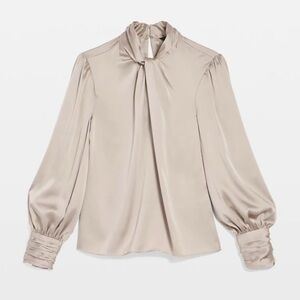 This satin blouse has a twisted neckline keyholes and blouson sleeves for flair